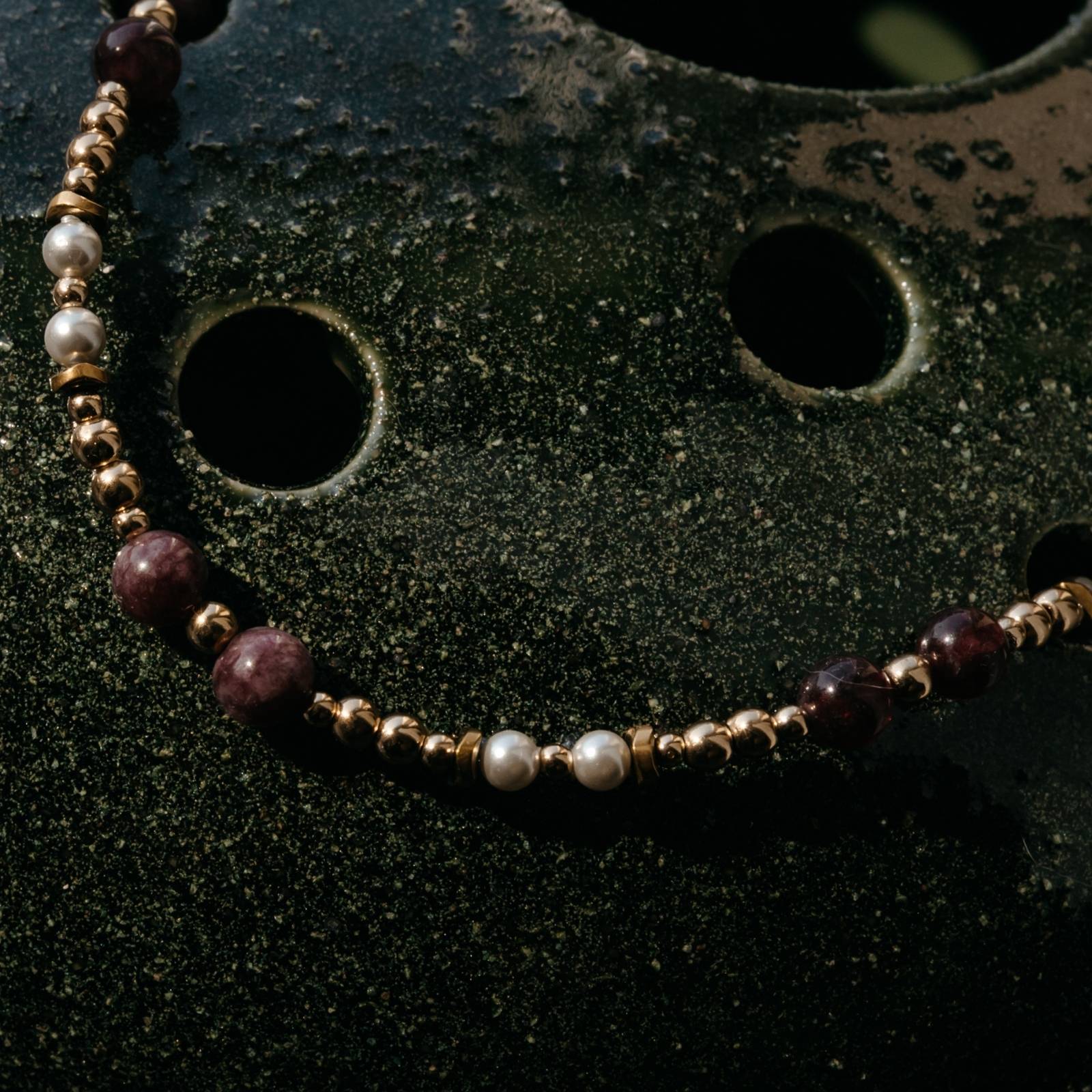 Zbliżenie bransoletki z granatu, pereł i hematytu – detale naturalnych kamieni i złotych elementów premium