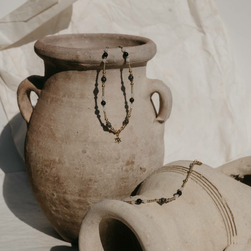 Zestaw naszyjnik i bransoletka z kamieni naturalnych z zawieszką gwiazdy – labradoryt, hematyt, czarny agat i biały jaspis – styl boho na glinianym dzbanie